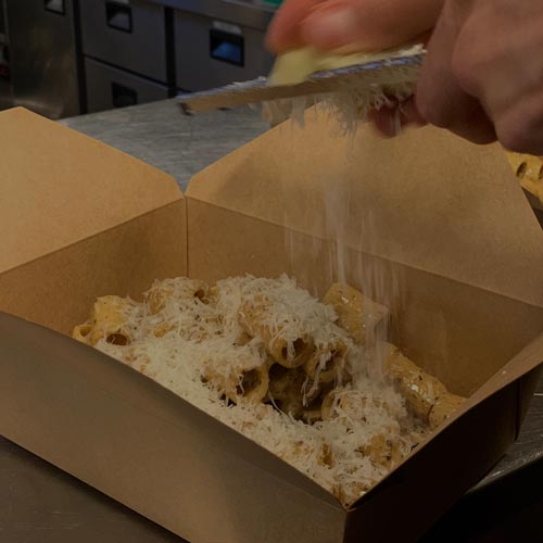 pasta i en låda som får ost på sig